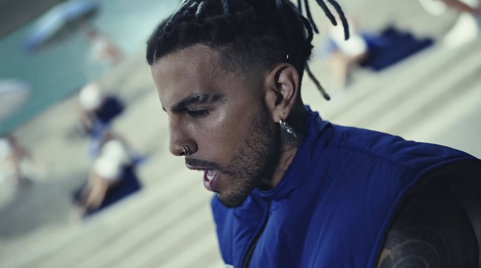 a man with dreadlocks looking down at his cell phone