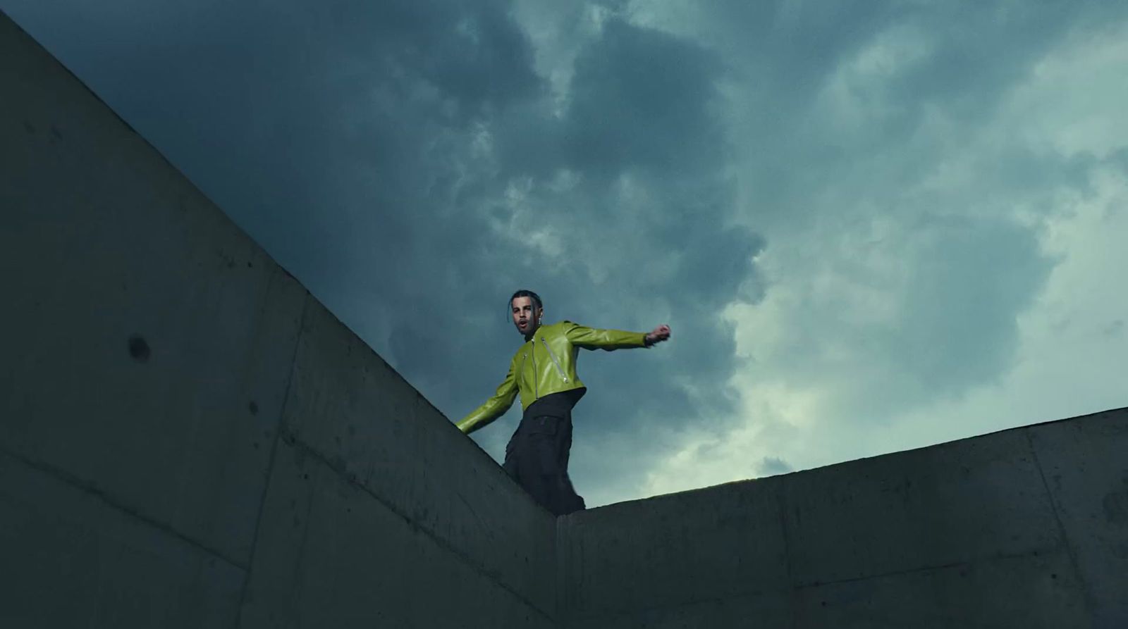 a man standing on a wall with his arms outstretched