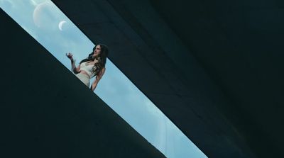 a woman in a white dress standing on a ledge