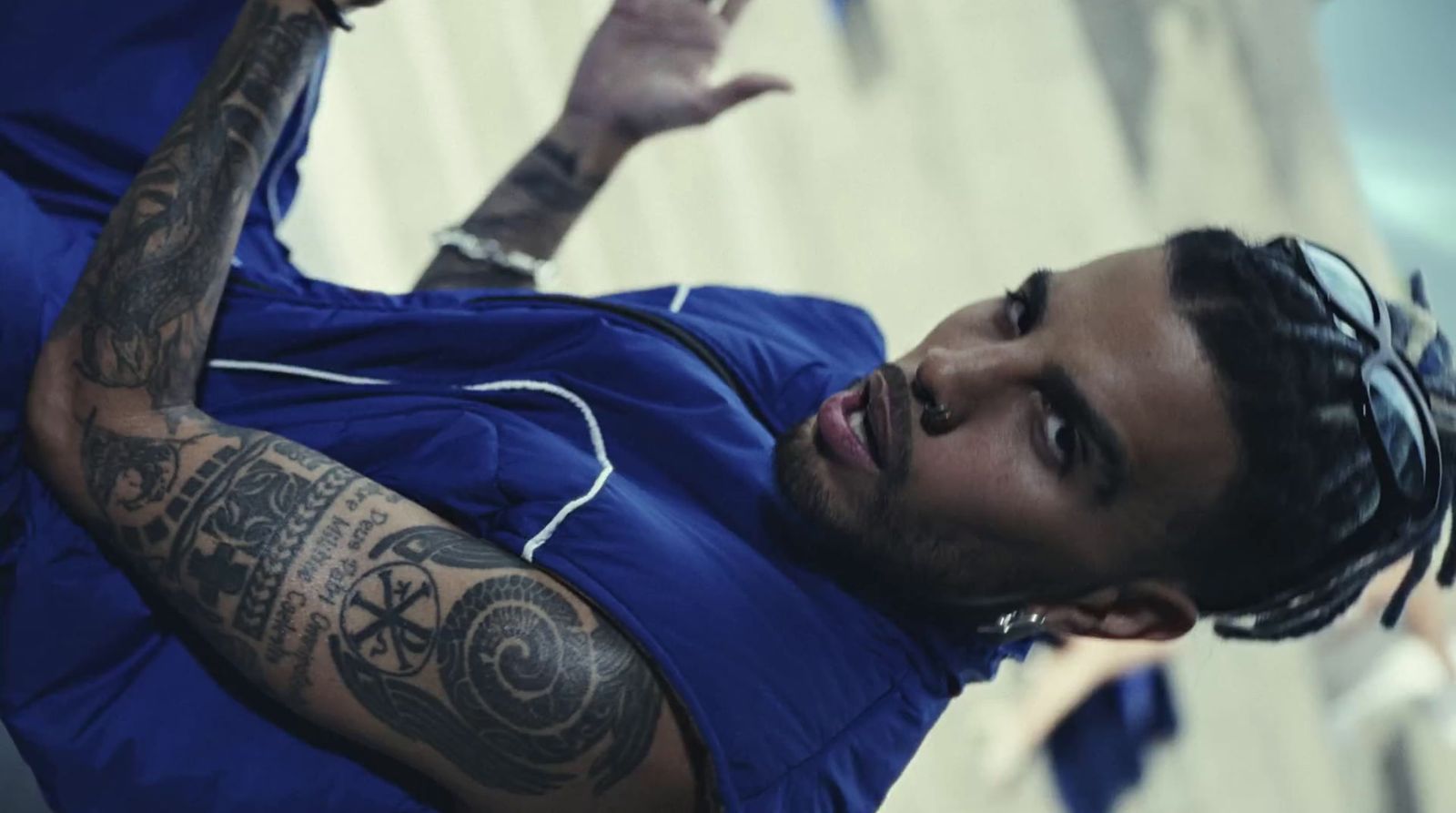 a man with a tattoo on his arm wearing a blue shirt