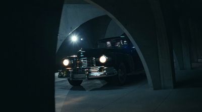 a black car driving through a tunnel at night