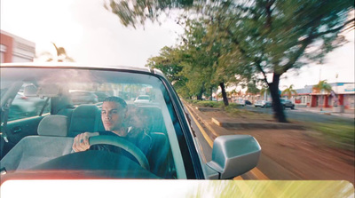 a woman driving a car down a street