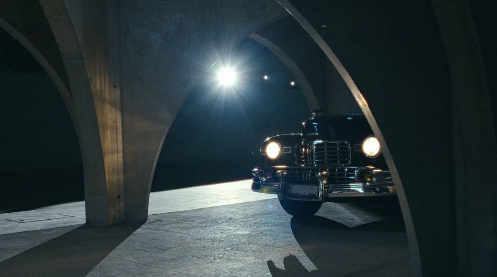 a truck driving under a bridge at night