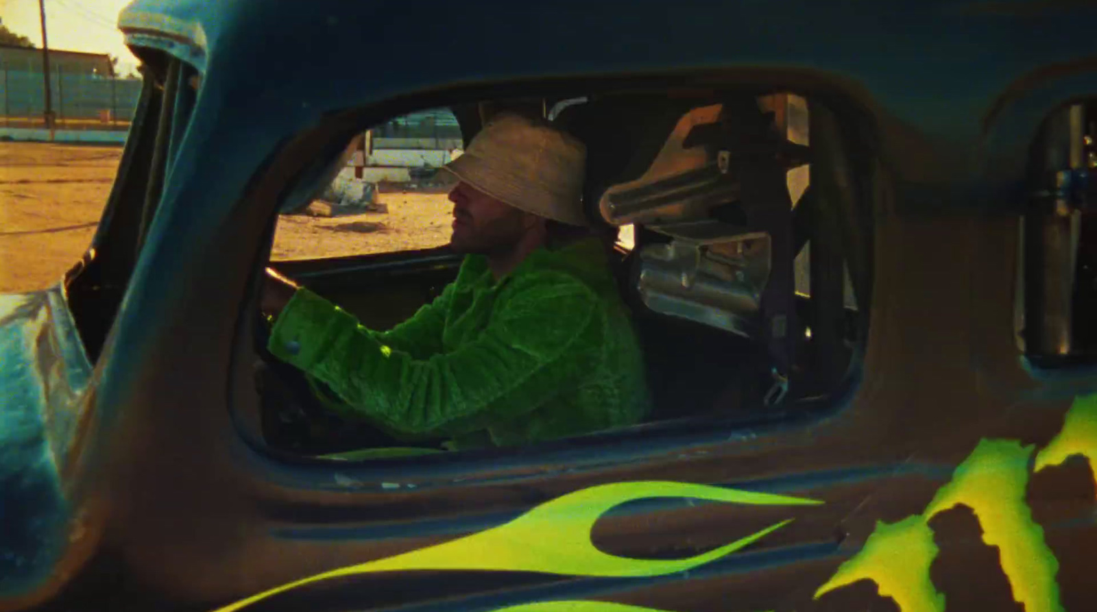 a man in a green jacket driving a truck