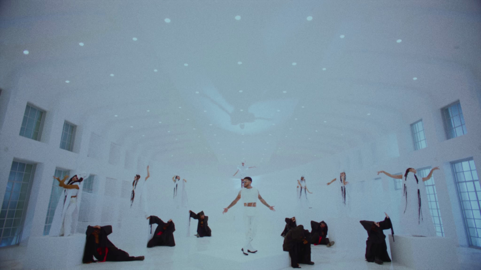 a man standing in front of a white room filled with mannequins