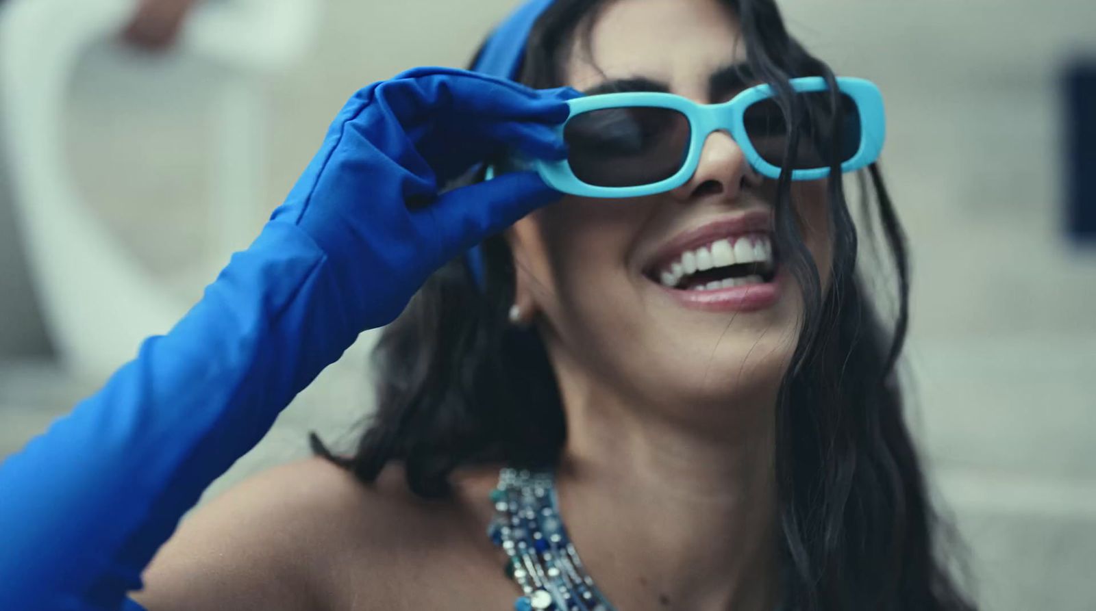 a woman wearing blue gloves and a pair of sunglasses