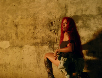 a woman with red hair sitting on a suitcase