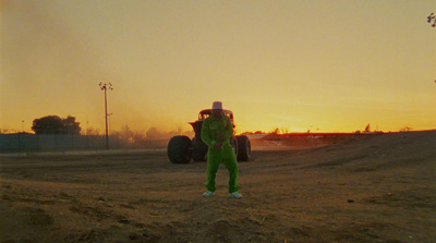 a person in a green suit standing in the dirt