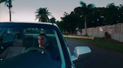 a man driving a car down a street