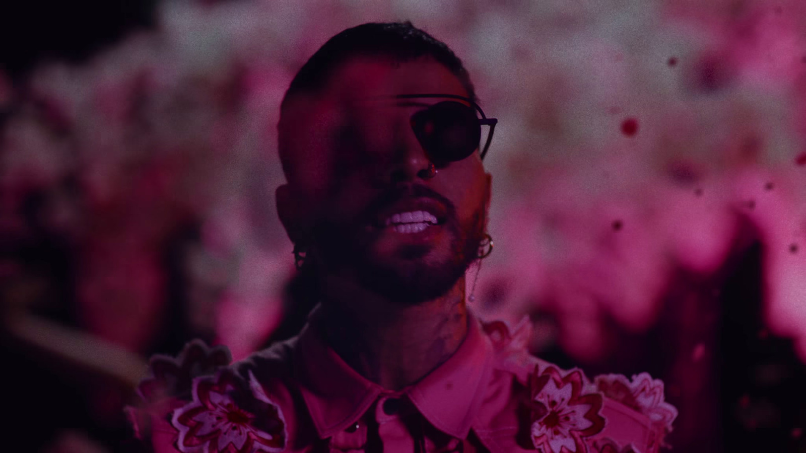 a man wearing sunglasses and a pink shirt