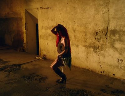 a woman with red hair is dancing in a dark room