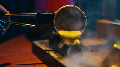 a person using a pair of tongs to stir food