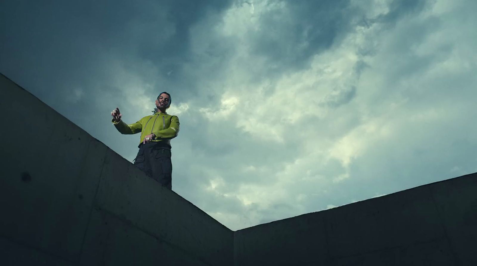 a man standing on top of a cement wall