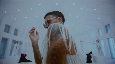 a man with tattoos wearing a white veil and sunglasses