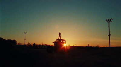 a truck driving down a road at sunset