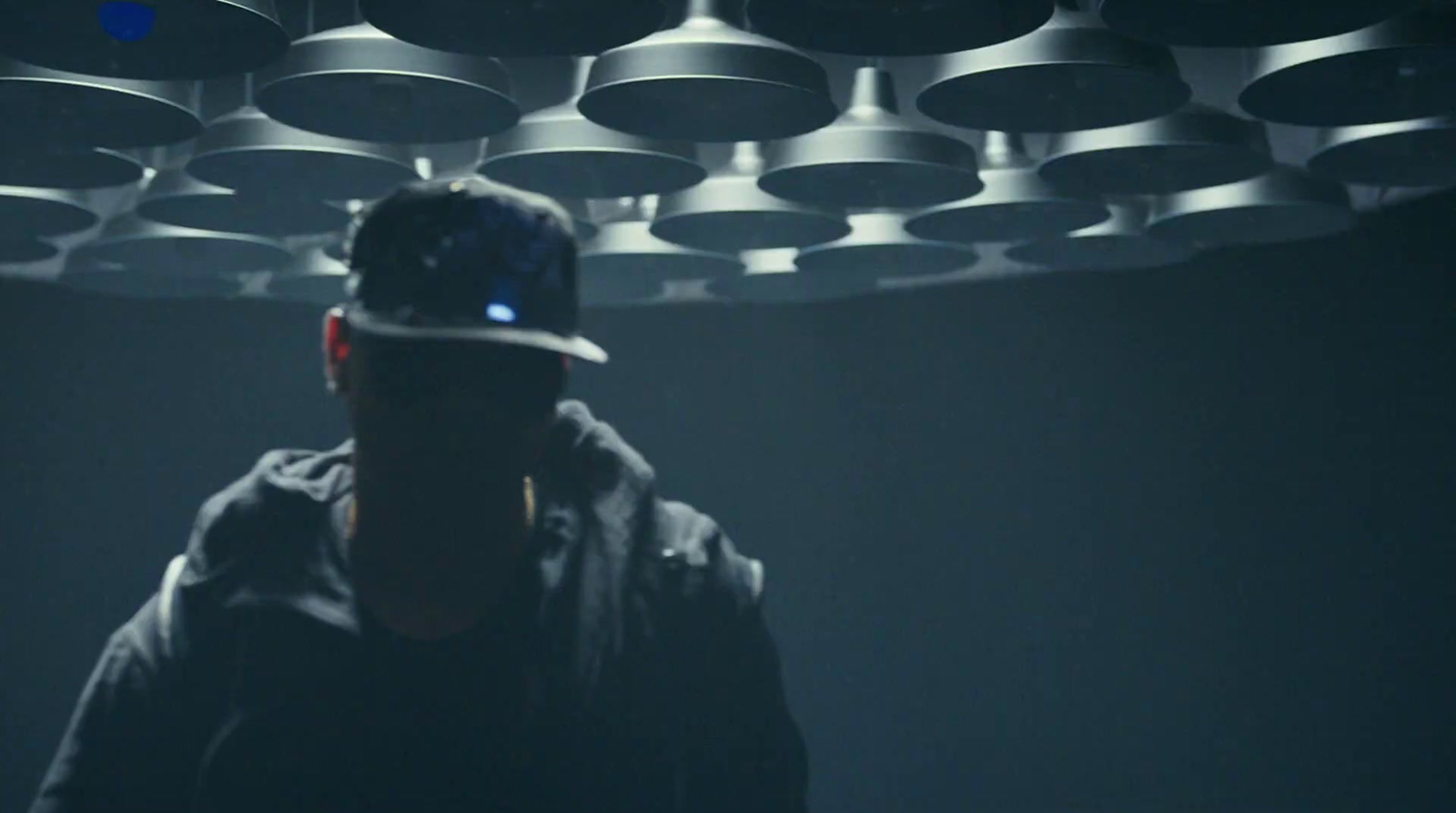 a man standing in front of a ceiling of bells