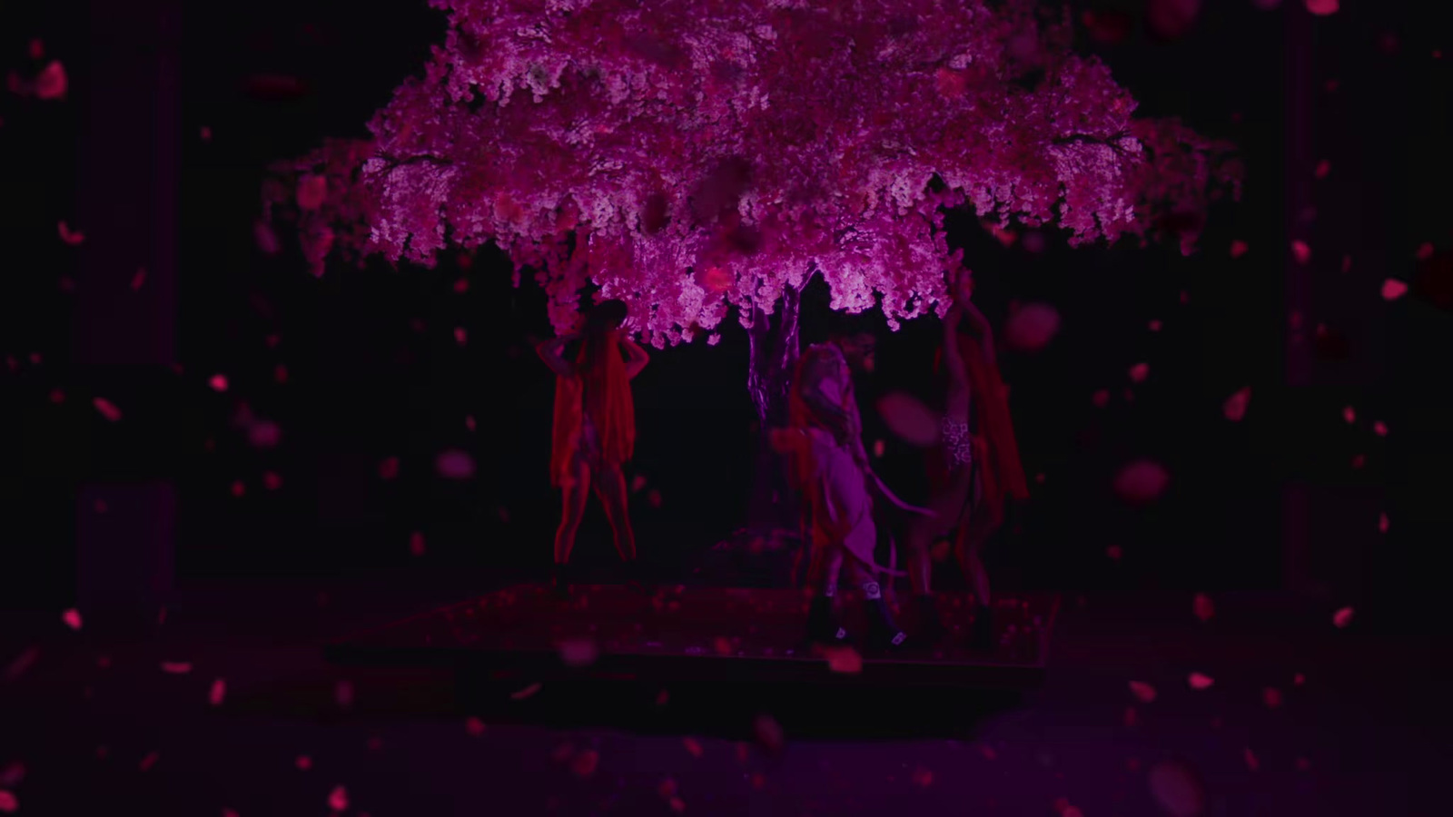 a pink tree in the middle of a dark room