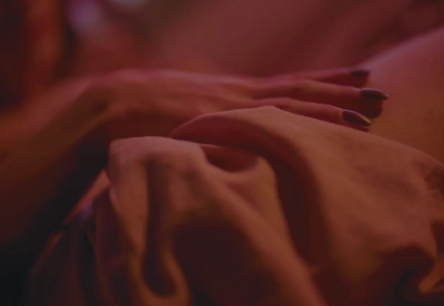 a close up of a person's hand with red nails