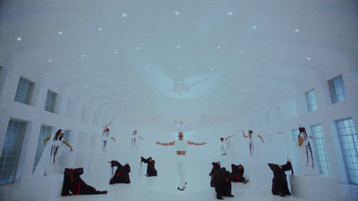 a group of people standing in a white room