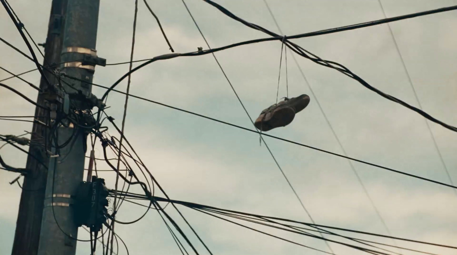 a pair of shoes hanging from a power pole