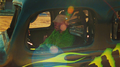 a man in a green jacket sitting in a car