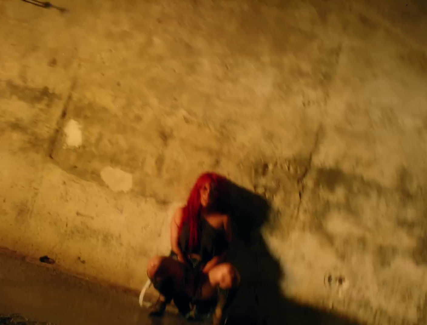 a woman with red hair sitting on a skateboard