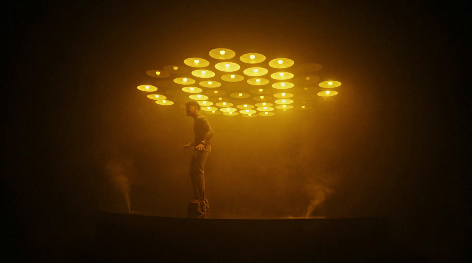 a man standing on top of a stage under a light