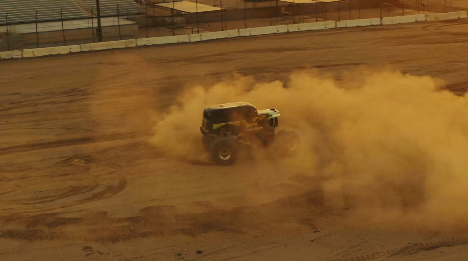 a truck is kicking up dust on a dirt track