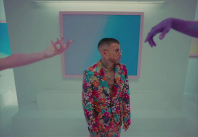 a man in a colorful shirt standing in front of a painting