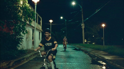 a man riding a bike down a street at night