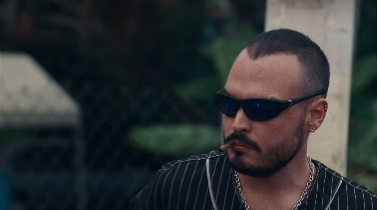 a man with a beard and sunglasses smoking a cigarette