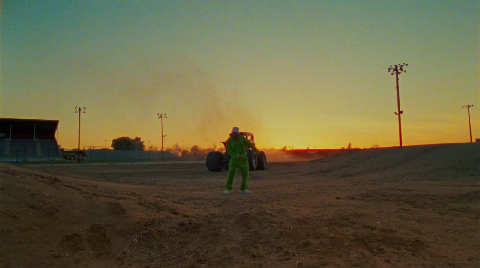 a person in a green suit standing in a dirt field