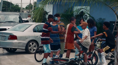 a group of people standing around a boy on a bike