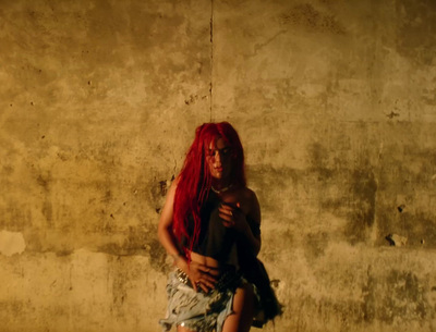 a woman with red hair standing in front of a wall