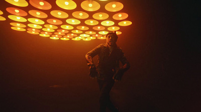 a man standing under a lit up umbrella in the dark