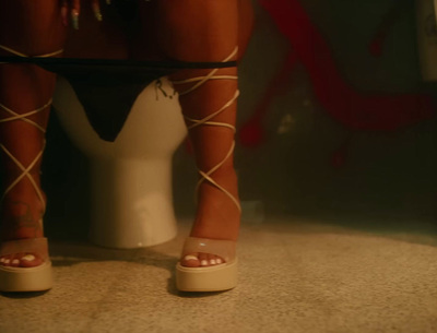 a woman's legs in high heels sitting on a toilet