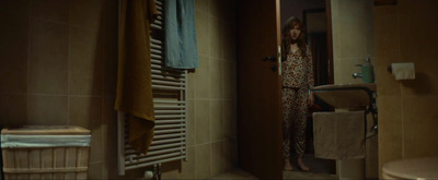 a woman standing in a bathroom next to a radiator