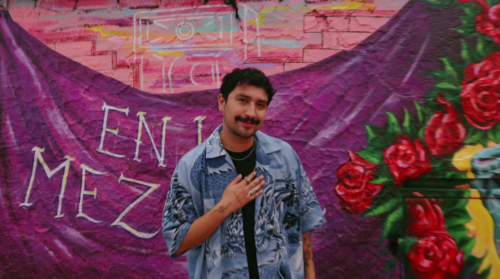 a man standing in front of a colorful wall