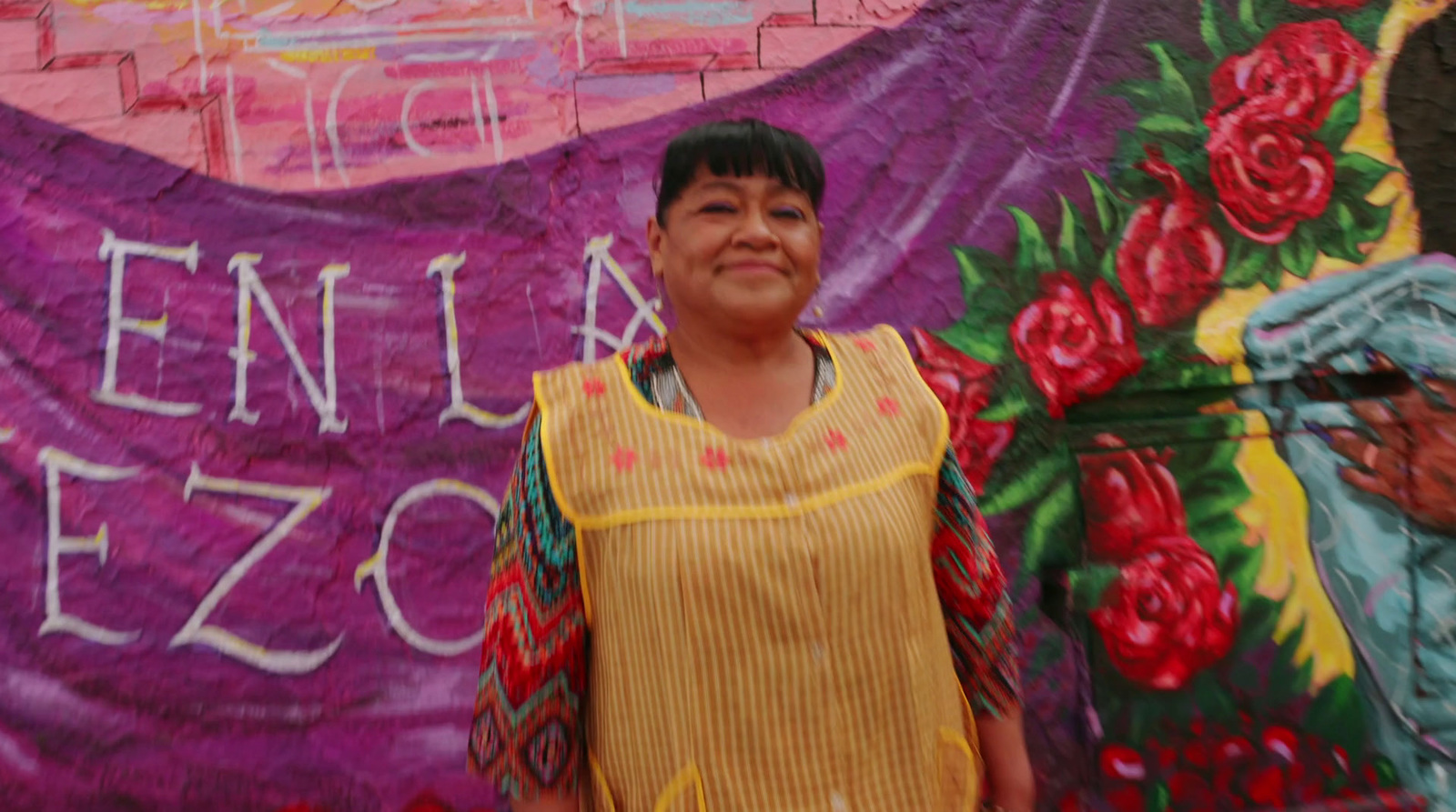 a woman standing in front of a mural