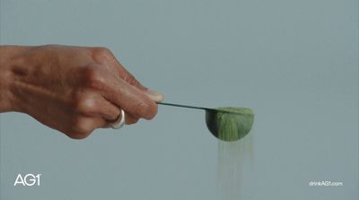 a hand holding a green object in the air