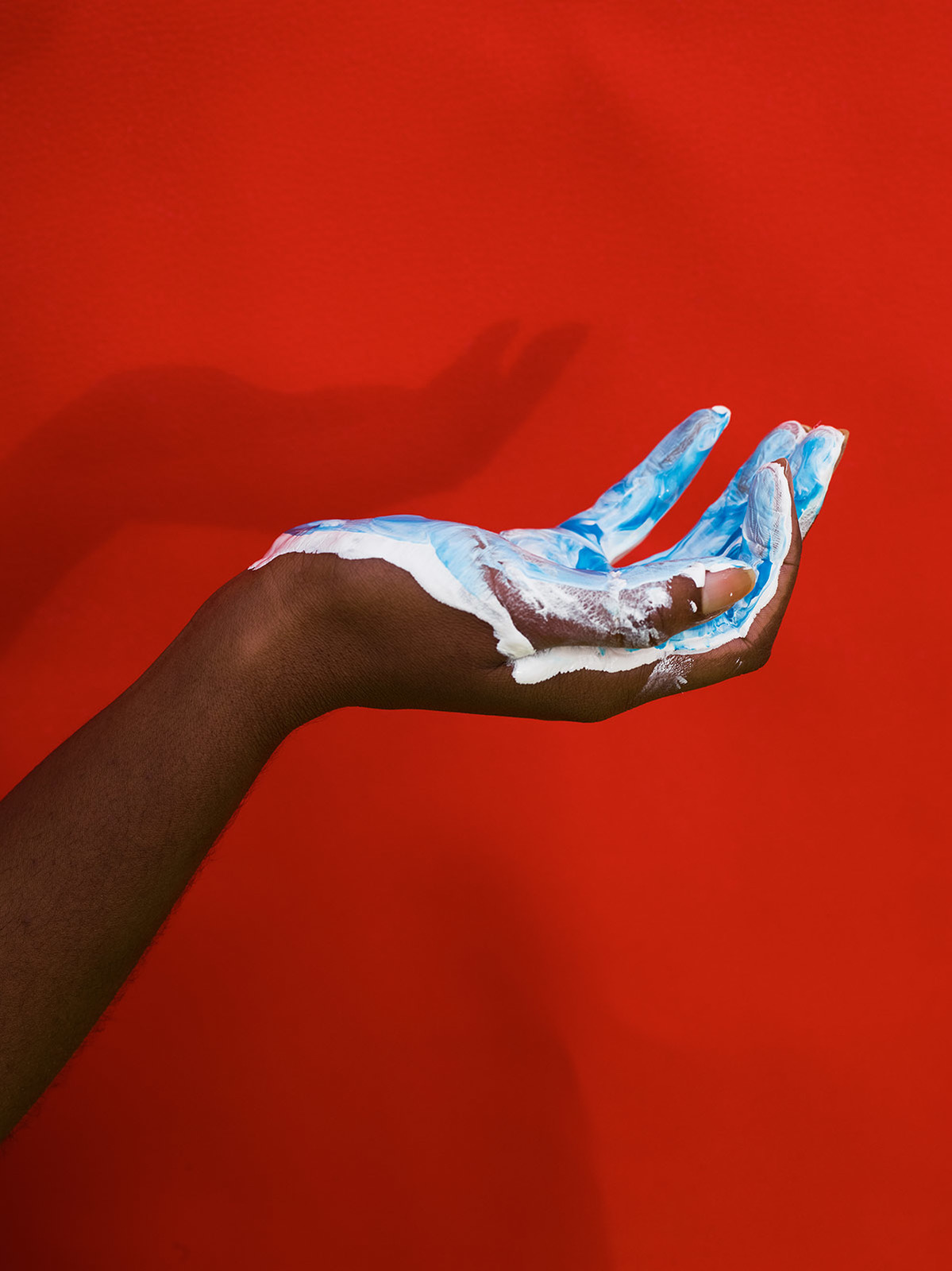 a person's hand with blue and white paint on it