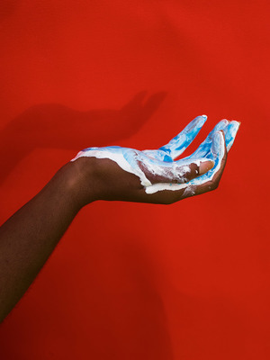 a person's hand with blue and white paint on it