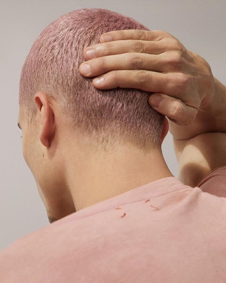 a man with a bald head holding his hands to his head