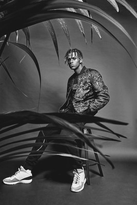 a man sitting on a chair in front of a plant