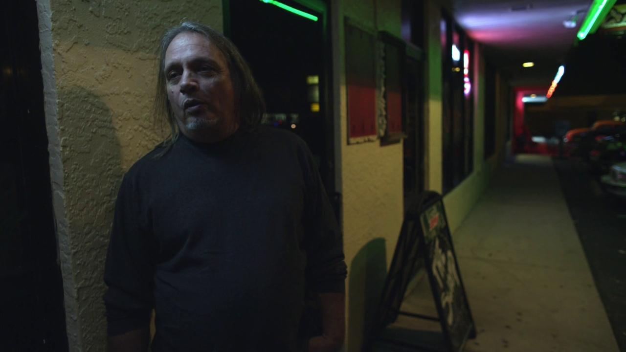 a man standing outside of a building at night