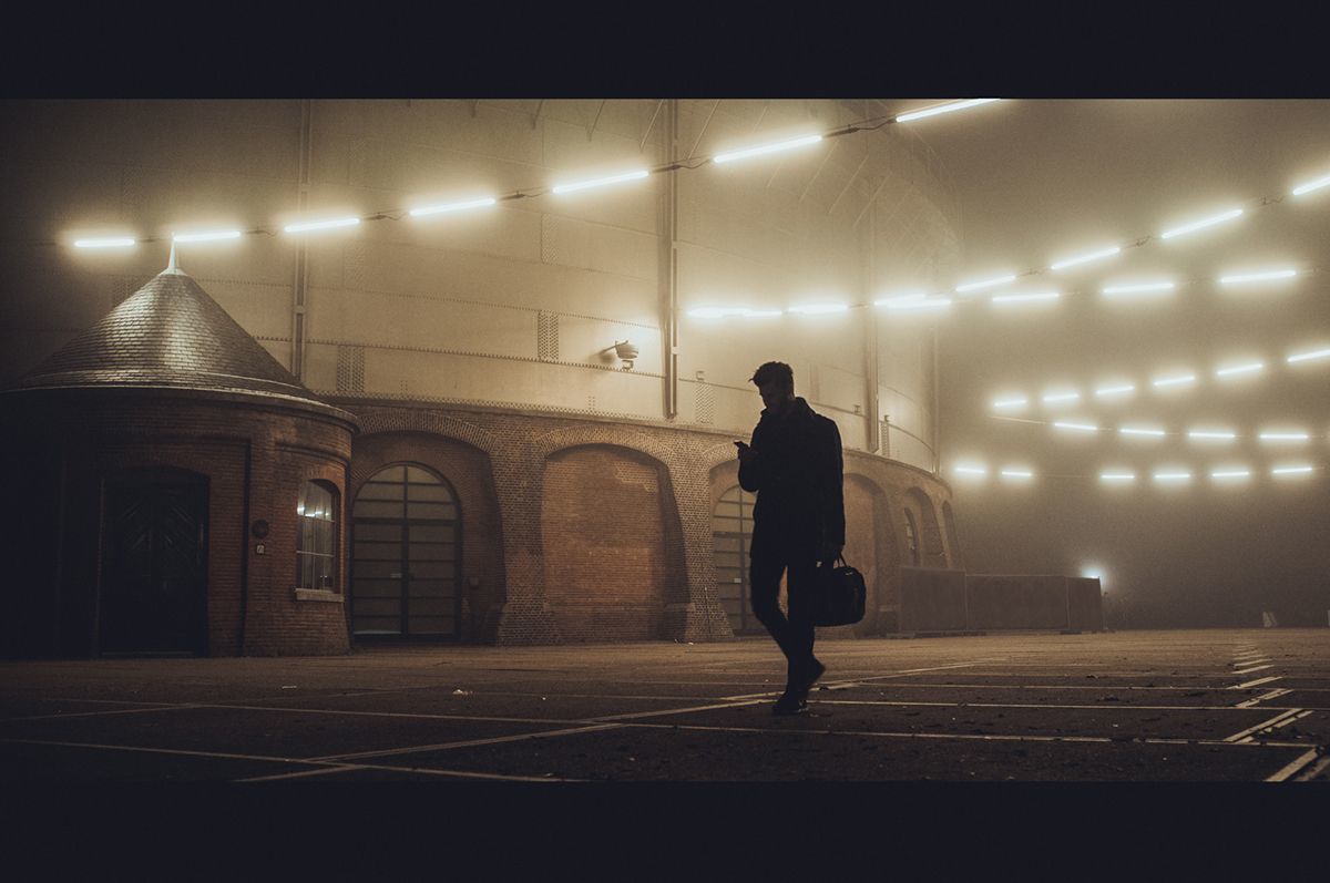 a man is walking in the fog in a stadium