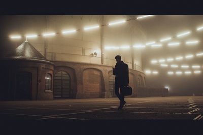 a man is walking in the fog in a stadium