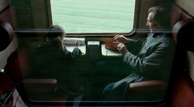 a man and a woman sitting on a train next to each other