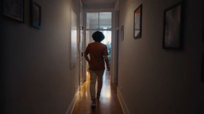 a person walking down a hallway in a house