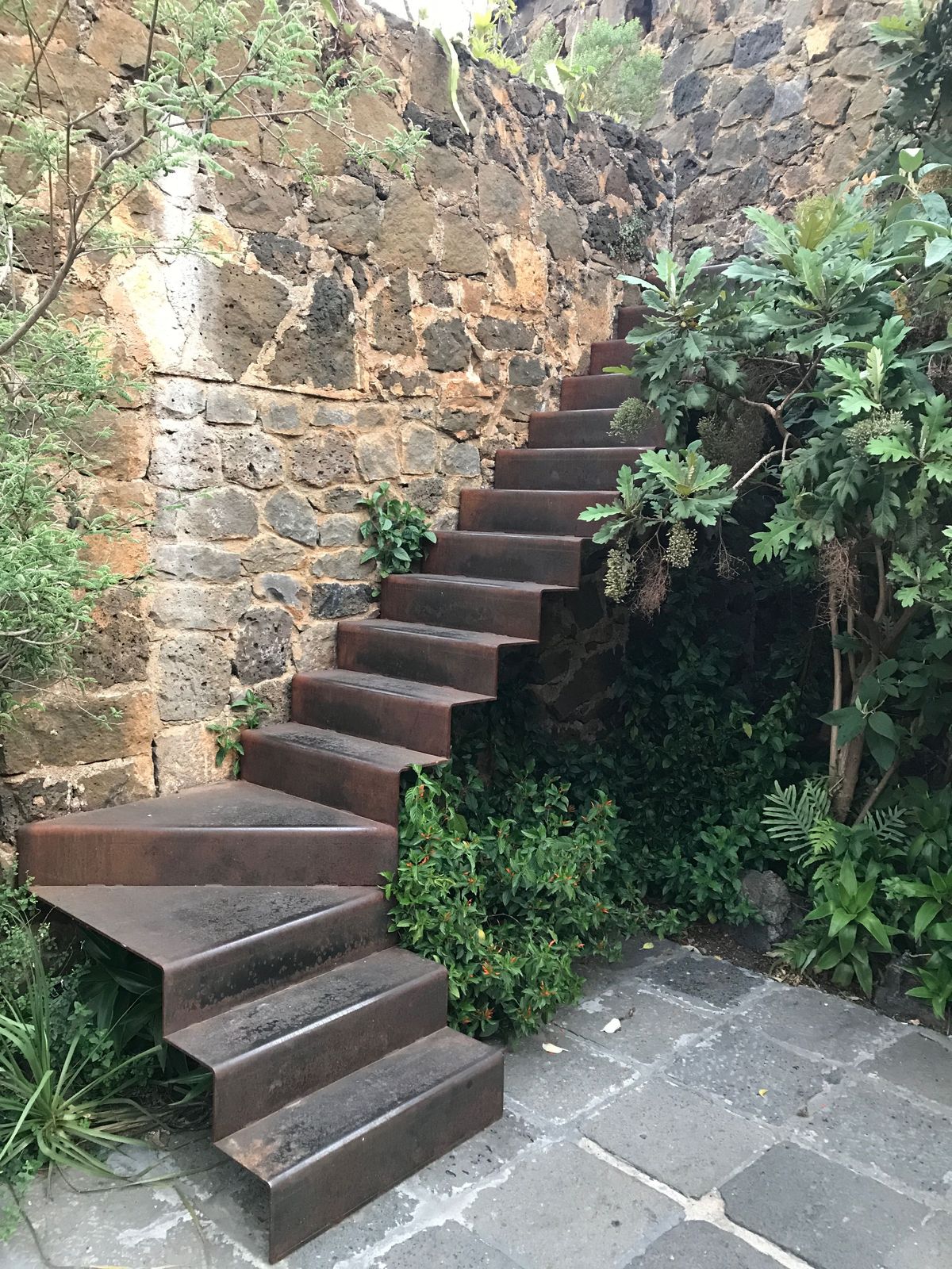 a set of stairs leading up to a stone wall